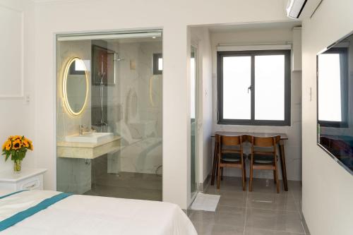 a bedroom with a bed and a sink and a mirror at Sun Hill Hotel in Vung Tau