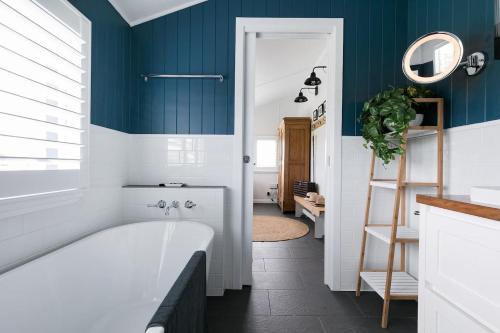 ein Badezimmer mit blauen Wänden und einer Badewanne in der Unterkunft Thirlestane Farm Cottage & Barn in Cooroy