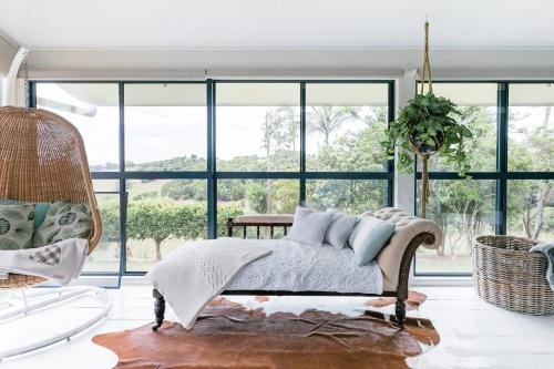 ein Schlafzimmer mit einem Bett und einem großen Fenster in der Unterkunft Thirlestane Farm Cottage & Barn in Cooroy