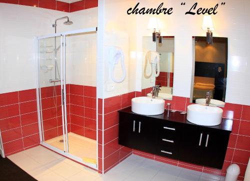 a bathroom with two sinks and a shower at Hotel de la Basilique in Paray-le-Monial