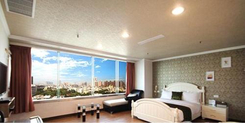 a bedroom with a bed and a large window at Ya Tai Hotel in Nanzi