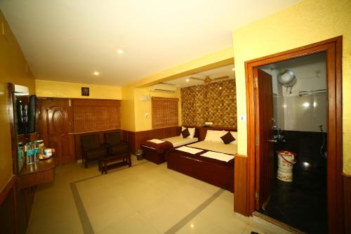 a room with a bedroom with a bed and a chair at Arudhra Residency in Chidambaram