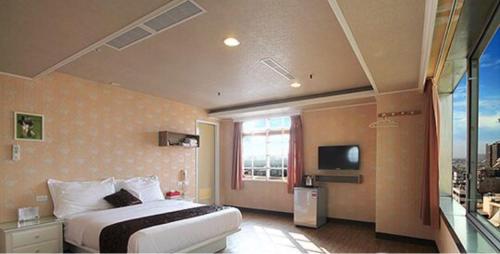 a hotel room with a bed and a window at Ya Tai Hotel in Nanzi
