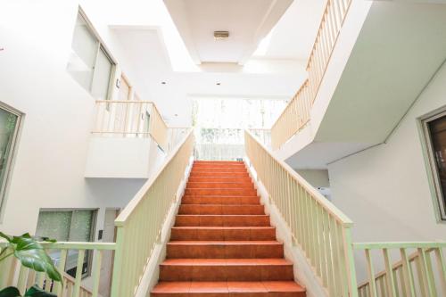 a staircase in a building with orange stairs at LeGreen Suite Penjernihan in Jakarta