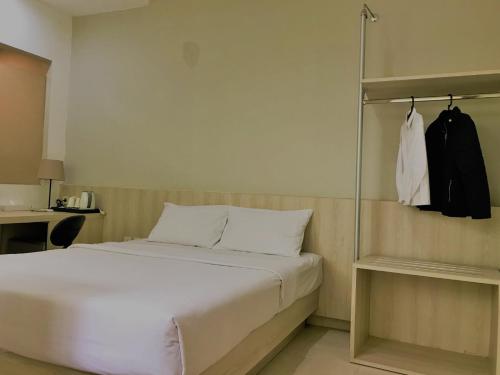 a bedroom with a white bed and a closet at LeGreen Suite Penjernihan in Jakarta