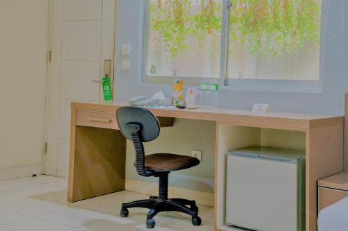 an office with a desk with a chair at it at LeGreen Suite Penjernihan in Jakarta