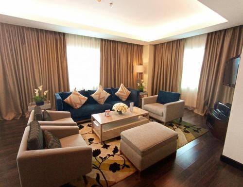 a living room with a couch and chairs and a table at Swiss-Belhotel Ambon in Ambon