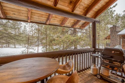 a screened in porch with a table and a grill at Wildflower 46 - Meredith Lodging in Sunriver