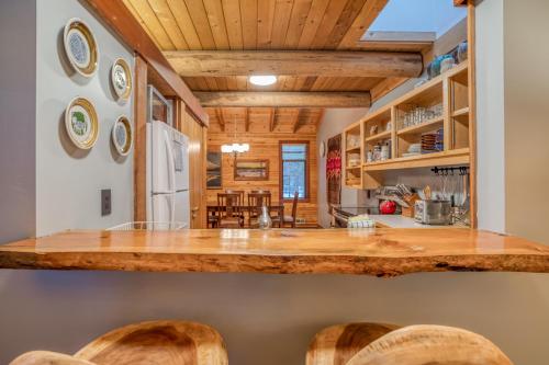 a kitchen with a counter top and wooden ceilings at Wildflower 46 - Meredith Lodging in Sunriver