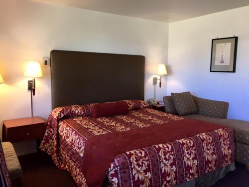 Habitación de hotel con cama y sofá en Maple Inn and Suites Los Banos, en Los Baños