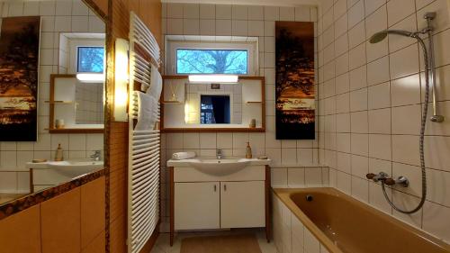 a bathroom with two sinks and a tub and a shower at A Mecsek Gyöngye Apartmanhaz in Pécs