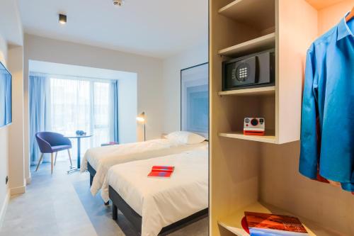 a hotel room with two beds and a tv at ibis Timisoara City Center in Timişoara