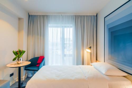 a hotel room with a bed and a table and a window at ibis Timisoara City Center in Timişoara