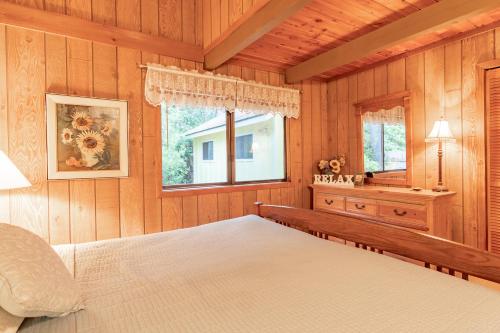 a bedroom with wooden walls and a bed and a window at Amazing Place MCA 1295 - Meredith Lodging in Manzanita