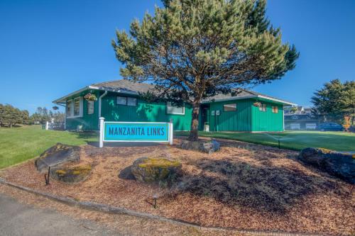 a sign in front of a green house with a tree at Amazing Place MCA 1295 - Meredith Lodging in Manzanita