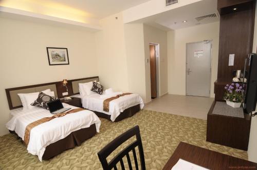 a hotel room with two beds and a television at Seemsoon Hotel in Ipoh