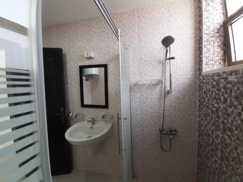 a bathroom with a sink and a shower with a sink at Furnished Apartments Near McDonald's Al-Madina Al-Monawara St in Amman