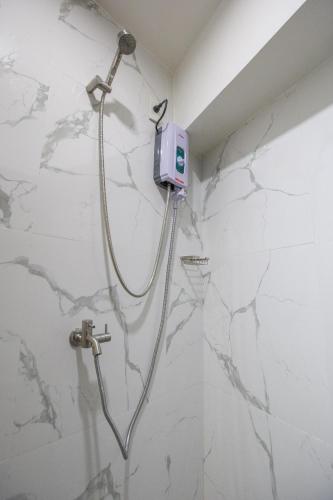 a shower in a bathroom with marble walls at Circuit Hostel in Manila