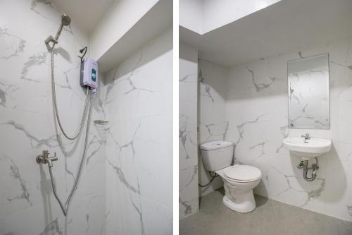 a bathroom with a shower and a toilet and a sink at Circuit Hostel in Manila