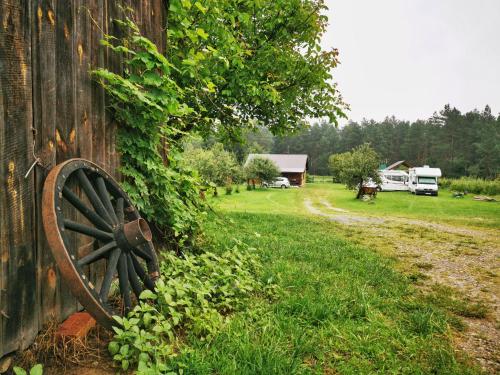 an old wagon wheel sitting on the side of a barn at Stawiska nad tanwia in Jędrzejówka