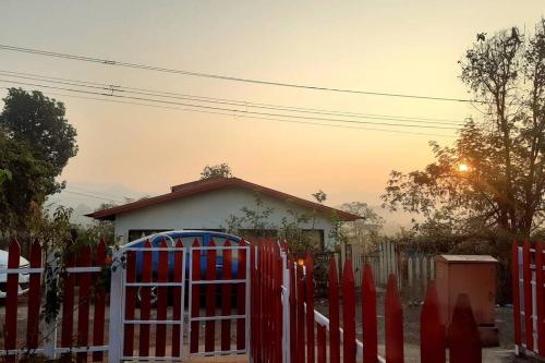 a red gate in front of a house at Joy Cottages - Premium Chalets, Vacation Home Rentals in Karjat