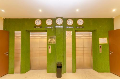 a row of elevators with clocks on a wall at Aladdin Dream Hotel in Johor Bahru