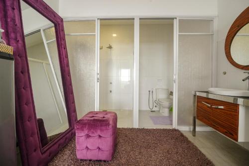 a bathroom with a pink ottoman in front of a mirror at Voda Krasna Resort & Restaurant in Alcoy
