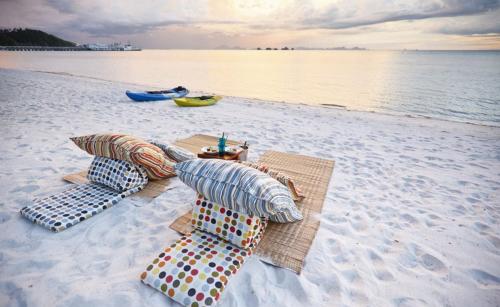 a table and chairs on a beach near the water at Baan Kilee in Lipa Noi