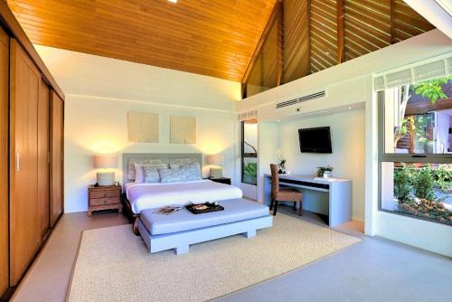 a bedroom with a bed and a desk and a television at Baan Kilee in Lipa Noi