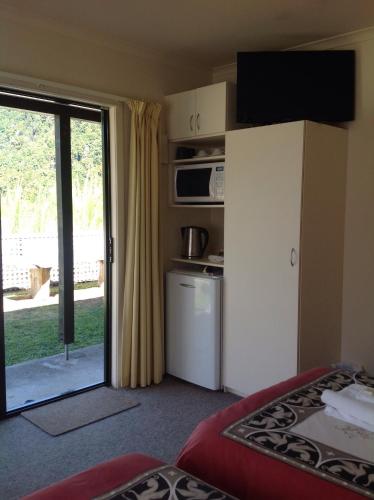 a room with a kitchen and a door to a patio at Owen River Tavern & Motels in Owen River