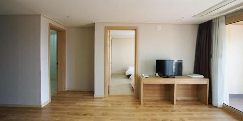a room with a desk with a television on it at Hi Jeju Hotel in Jeju