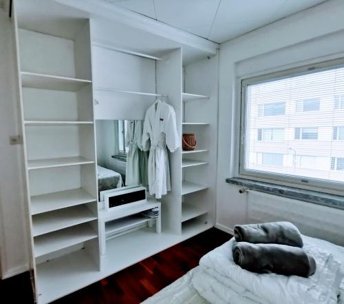 a bedroom with white shelves and a bed and a window at City Pearl in Jyväskylä