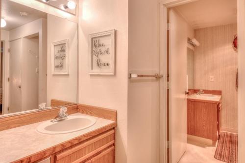 W łazience znajduje się umywalka i lustro. w obiekcie Dock of the Bay 305 w mieście Lincoln City