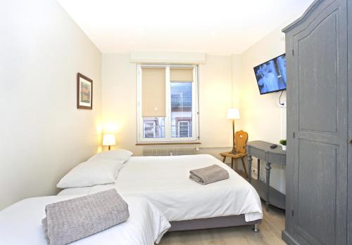 a bedroom with two beds and a desk and a window at Centre - L'Impérial - Parking in Saverne