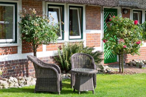 two wicker chairs sitting in front of a house at Ferienwohnungen von Schassen in Twielenfleth