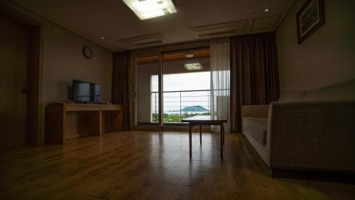 a living room with a large window and a couch at Hi Jeju Hotel in Jeju