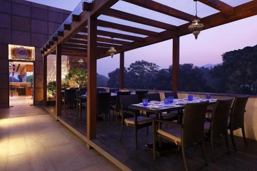 a dining room with a table and chairs on a deck at Radisson Blu Hotel Guwahati in Guwahati