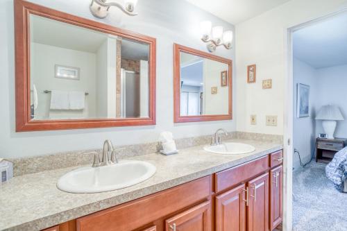 a bathroom with two sinks and two mirrors at Dock of the Bay 308 in Lincoln City