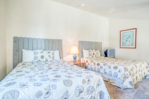 a bedroom with two beds and a table with a lamp at Dock of the Bay 308 in Lincoln City