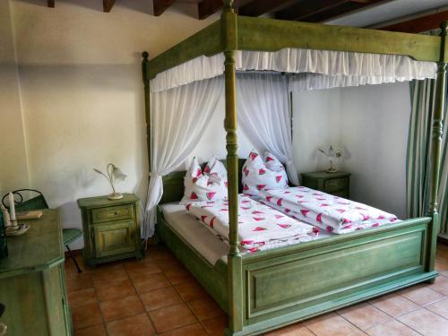 ein Schlafzimmer mit einem Himmelbett und zwei Nachttischen in der Unterkunft Landhaus am See von Robertville in Weismes