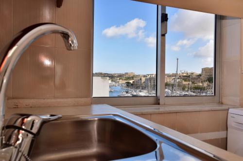 a kitchen sink with a window with a view of a harbor at 2 Bedroom, Bright & Central Top Floor Apartment - 5 in Msida