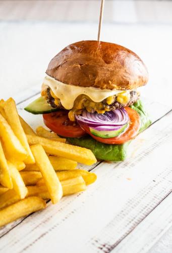 a hamburger with french fries on a plate at Residence Hotel Balaton in Siófok