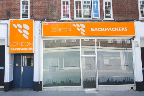 two orange signs on the side of a building at London Backpackers Youth Hostel 18 - 35 Years Old Only in London