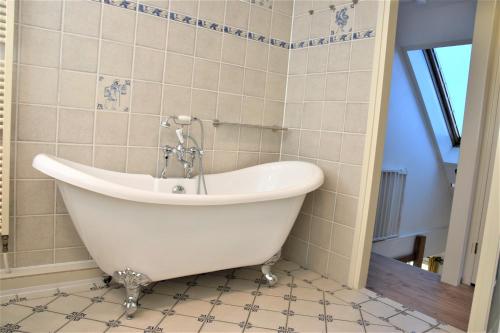 een bad in een badkamer met een tegelvloer bij Buitenplaats Villa 6-p in Callantsoog