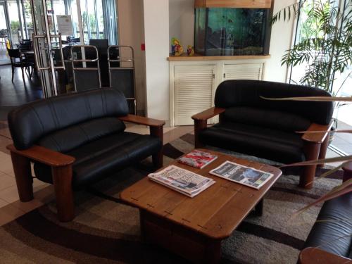 
a living room filled with furniture and a coffee table at Cairns Sheridan Hotel in Cairns
