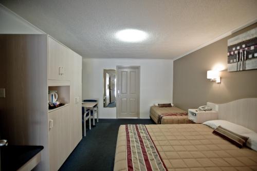 a hotel room with a bed and a desk at Centrepoint Motor Inn in Rockhampton