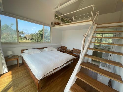1 dormitorio con litera y escalera en Golden101 Bed and Breakfast, en Jiufen
