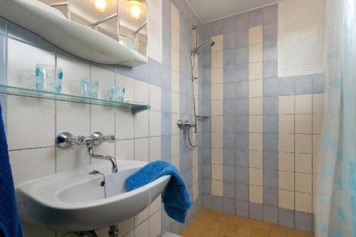 Parchtitz的住宿－RügenHerz Fischerhütte，一间带水槽和蓝毛巾的浴室