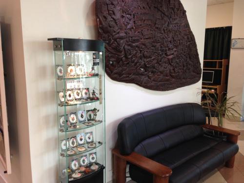 a room with a leather chair and a display case at Cairns Sheridan Hotel in Cairns