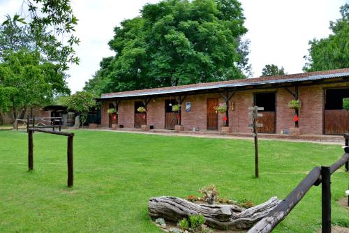 a brick building with a yard with a log at Owls Loft Guest House in Midrand